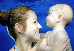 baby swimming with mum under water